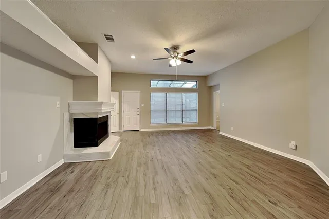 a view of an empty room with a fireplace and a window