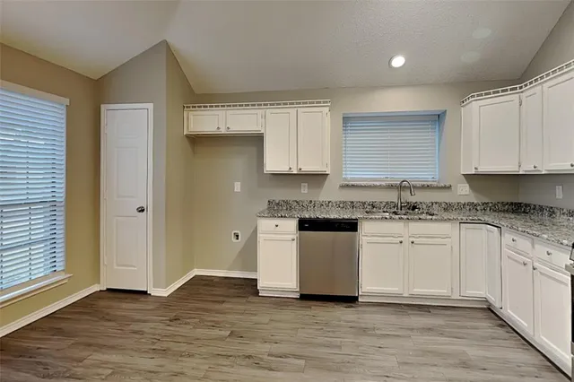a kitchen with granite countertop white cabinets and white appliances