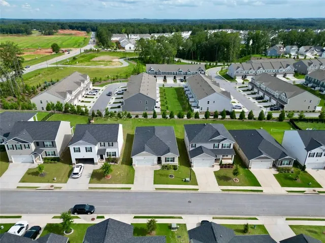 an aerial view of residential houses with outdoor space and swimming pool