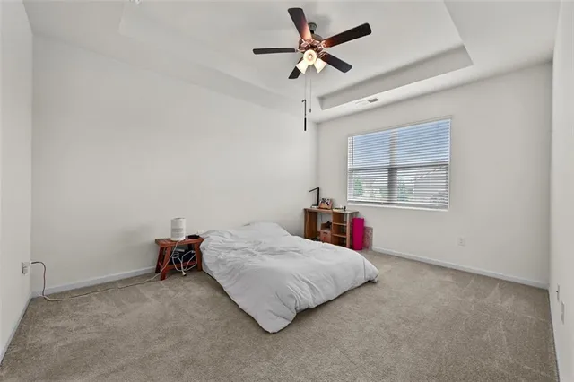 a bedroom with a bed and a ceiling fan