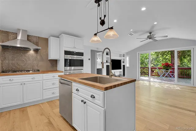 a kitchen with a refrigerator a stove a sink dishwasher and white cabinets with wooden floor