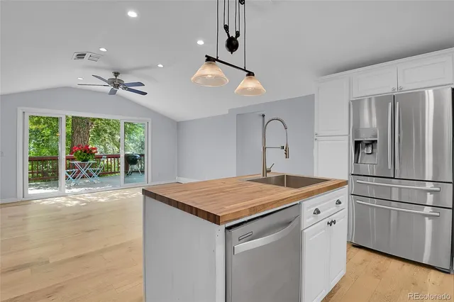 a kitchen with stainless steel appliances granite countertop a refrigerator and a stove top oven