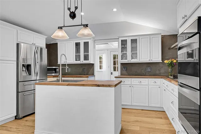 a large kitchen with cabinets and wooden floor