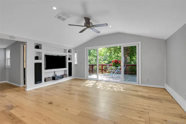 a view of living room kitchen with stainless steel appliances kitchen island with cabinets