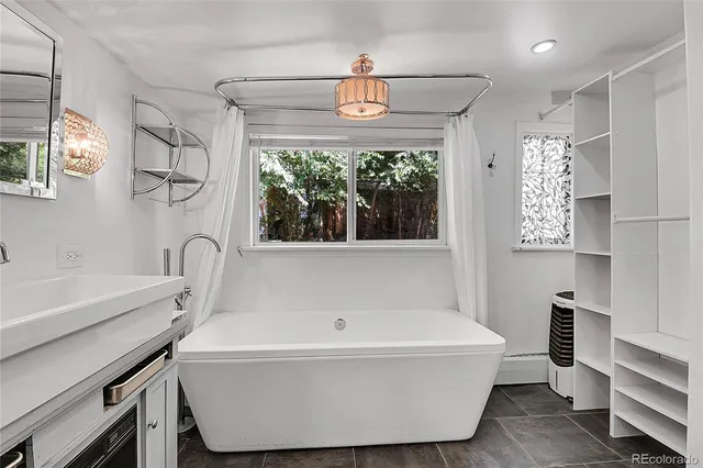 a bathroom with a sink a bathtub and a window