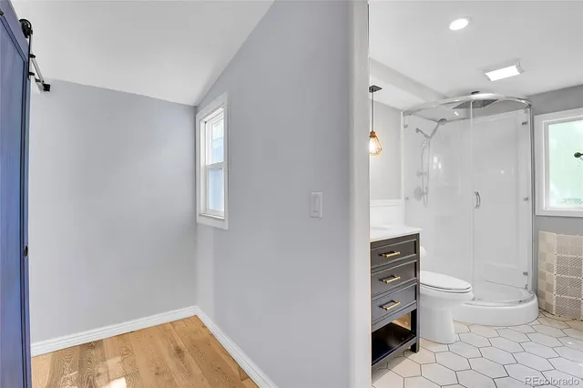 a bathroom with a sink a toilet a mirror and shower