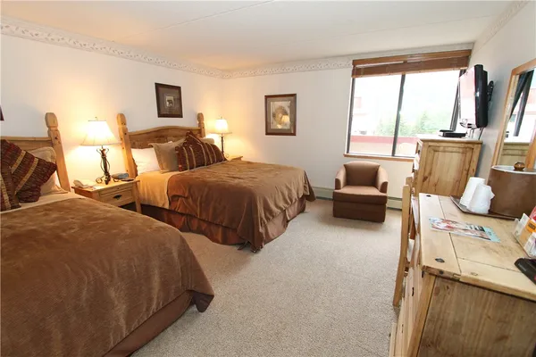 a large bedroom with two beds and large window