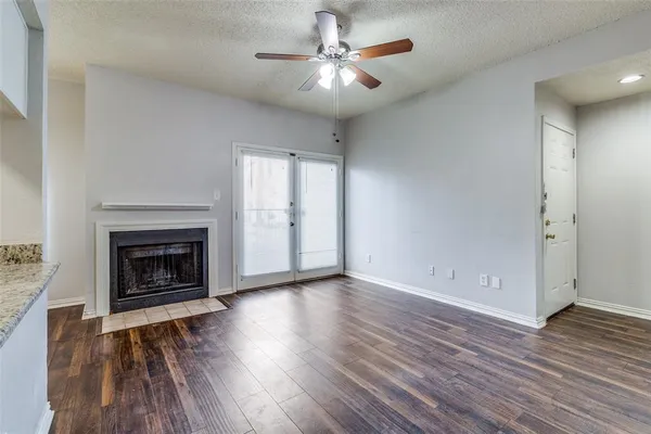 wooden floor fireplace and windows in an empty room