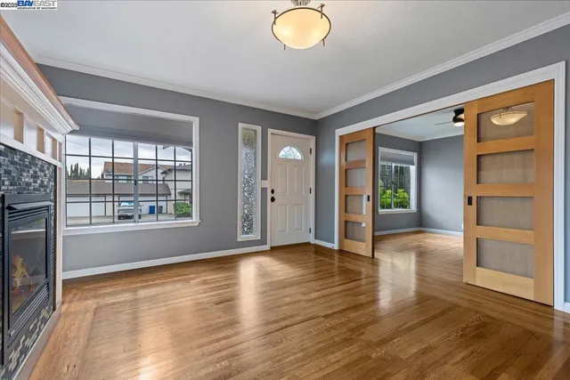 a view of empty room with wooden floor and fan