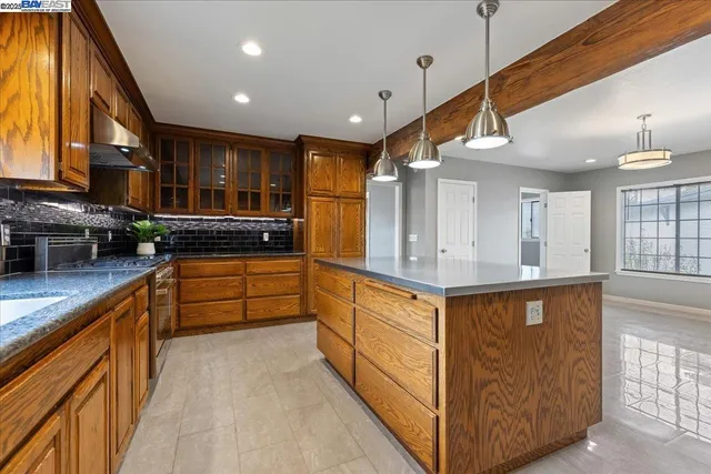 a kitchen with stainless steel appliances granite countertop a sink a stove and a refrigerator