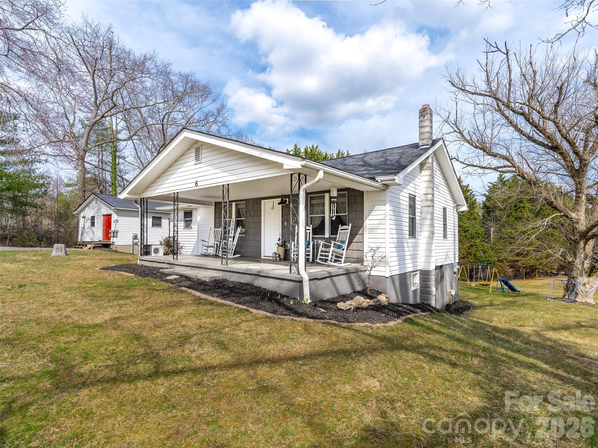 a view of a white house with swimming pool and wooden fence