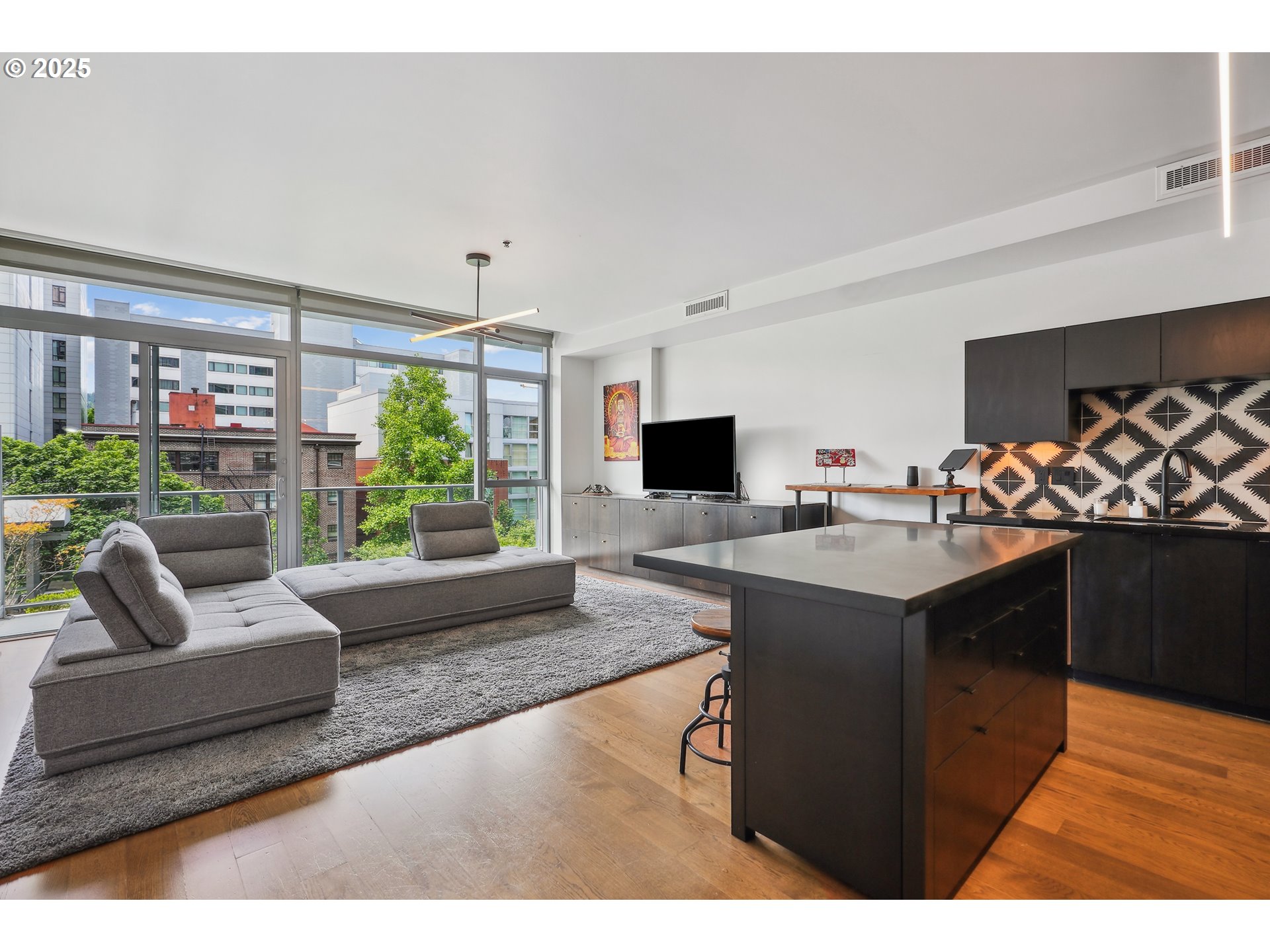 1221 Southwest 10th Avenue, Unit 410 Portland, OR 97205 - Photo 4 of 26 a living room with furniture a flat screen tv and a floor to ceiling window