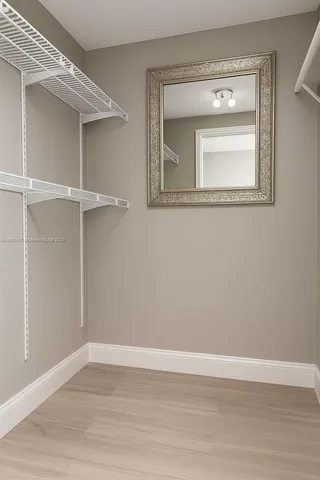 a view of a small space with wooden floor and a window