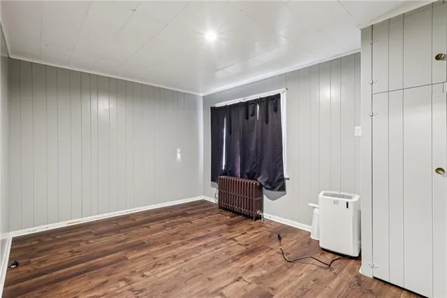 an empty room with wooden floor and bathroom