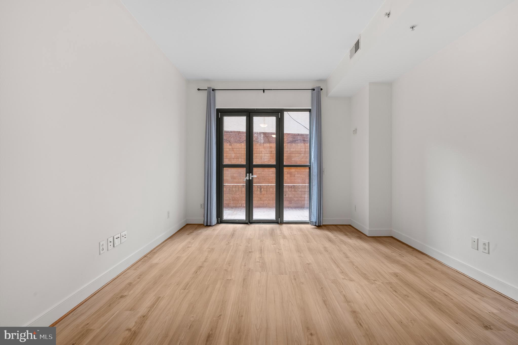 910 M Street Northwest, Unit 126 Washington, DC 20001 - Photo 17 of 54 an empty room with wooden floor and windows