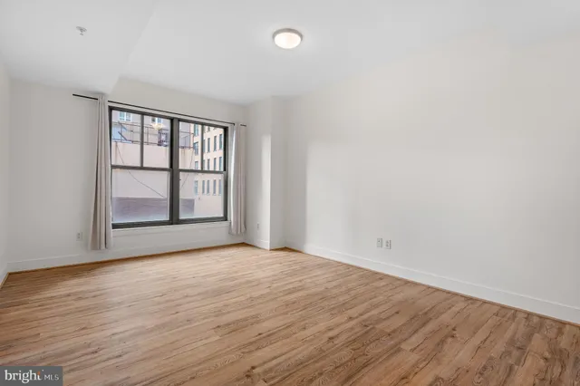 a view of an empty room with wooden floor