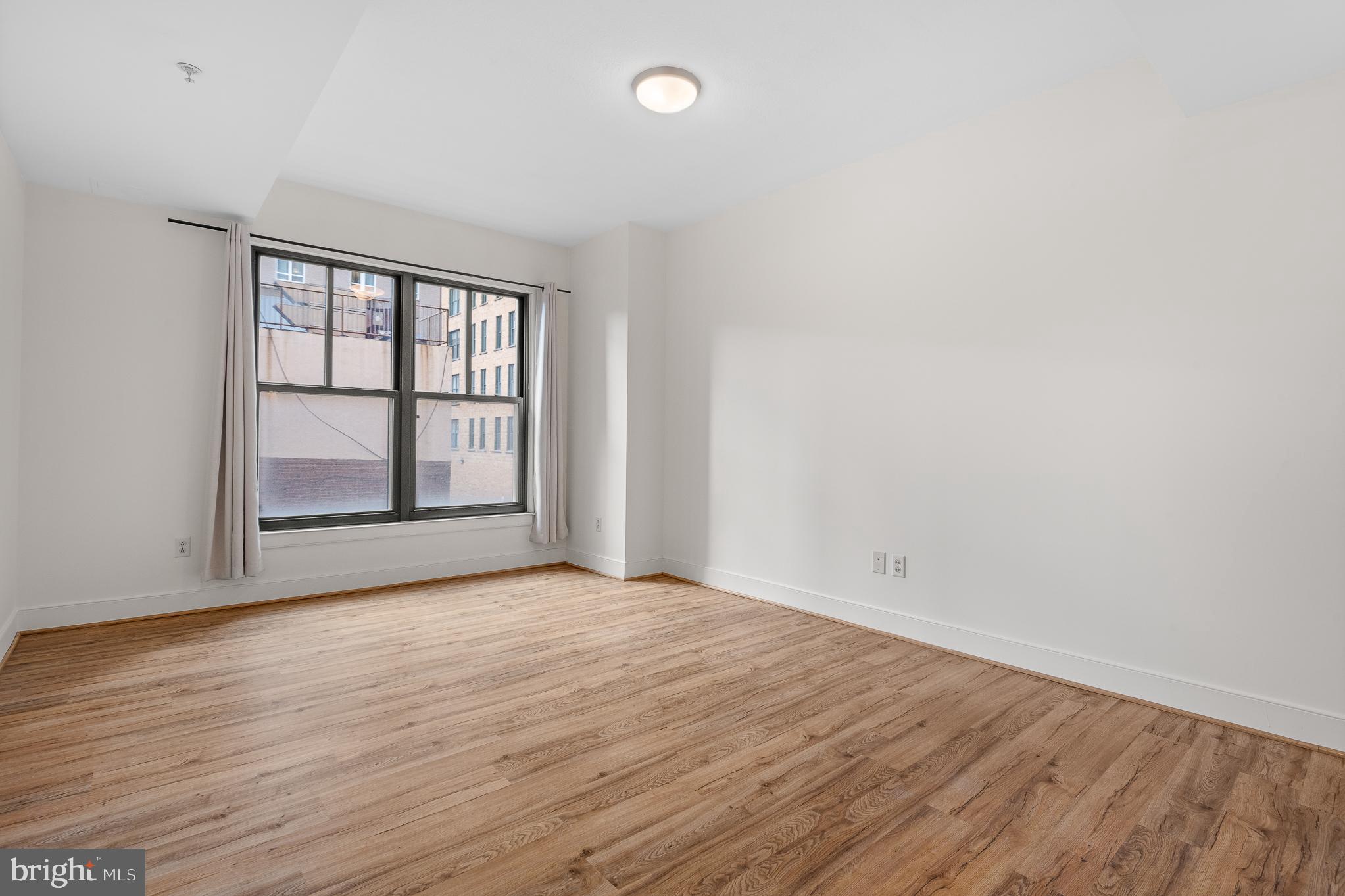 910 M Street Northwest, Unit 126 Washington, DC 20001 - Photo 22 of 54 wooden floor in an empty room with a window