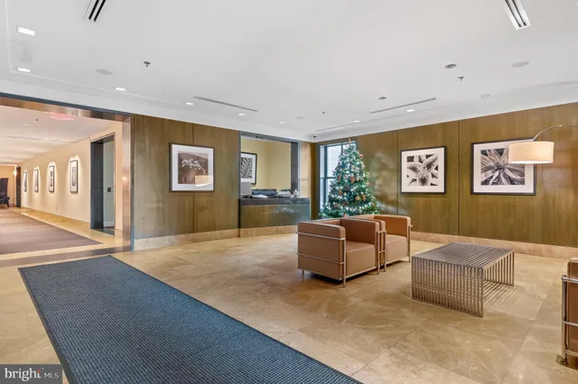 a living room with couches and kitchen view with wooden floor