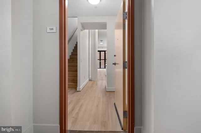 a view of a hallway with wooden floor and staircase
