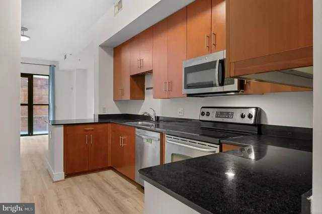 a kitchen with stainless steel appliances a stove microwave and sink