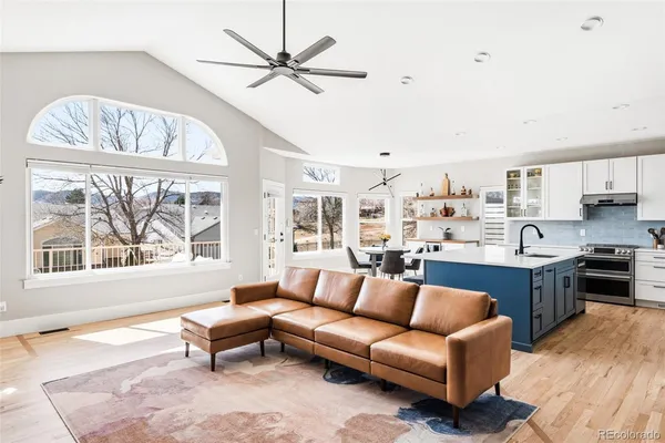a living room with stainless steel appliances a couch and a chandelier