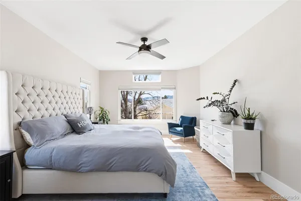 a bedroom with a large bed and a chandelier fan