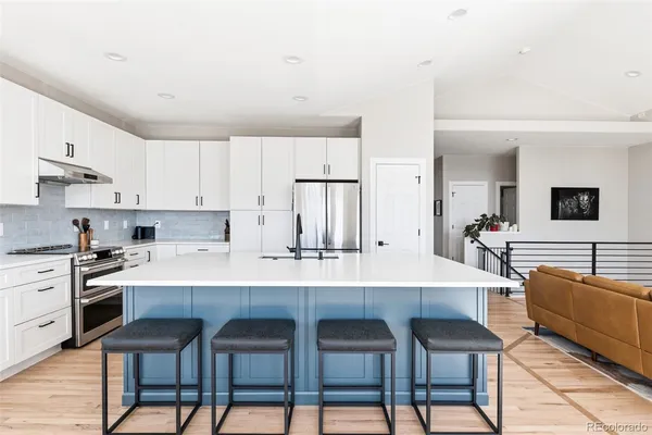 a kitchen with stainless steel appliances a table and chairs in it