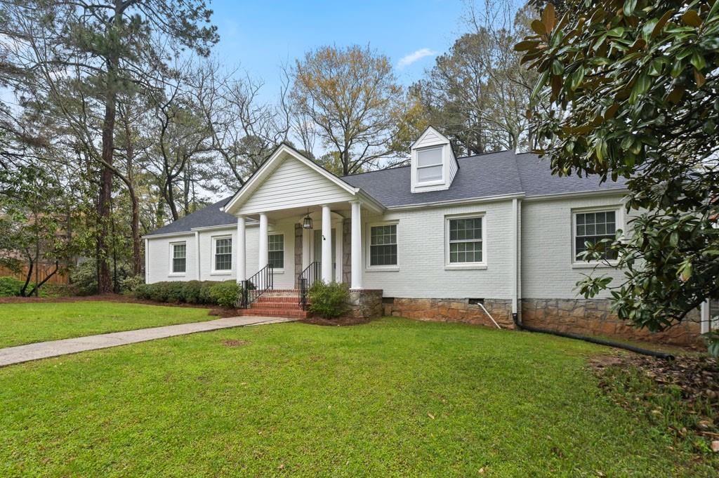 a front view of a house with a garden and yard
