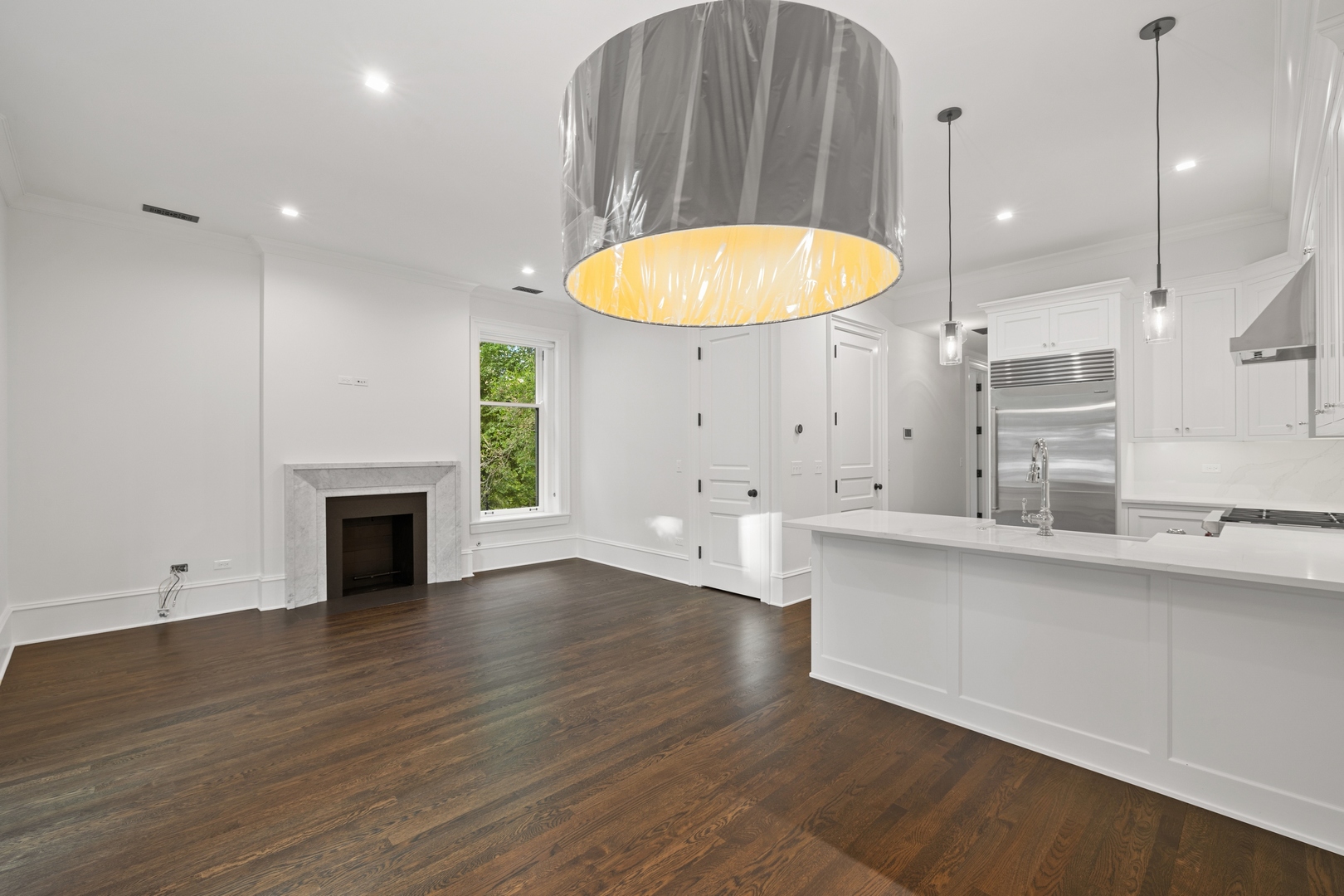 1300 North Ritchie Court, Unit 2 Chicago, IL 60610 - Photo 12 of 25 wooden floor in an empty room with a fireplace and a chandelier