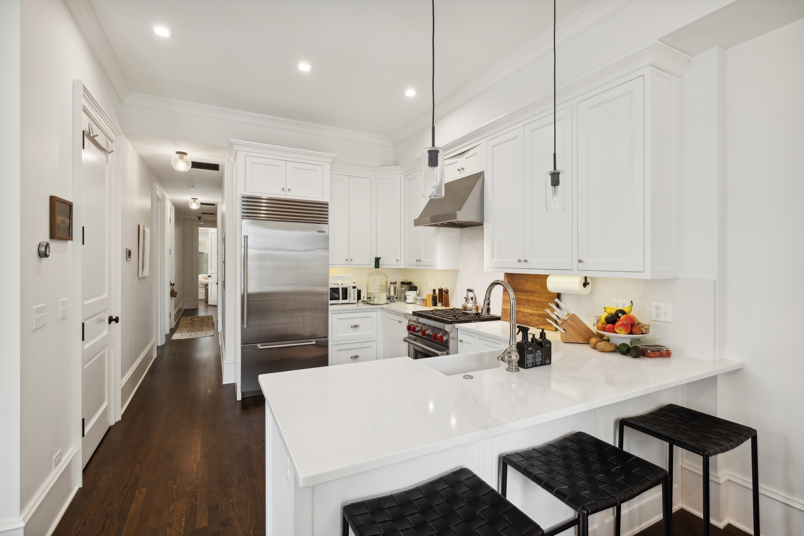 1300 North Ritchie Court, Unit 2 Chicago, IL 60610 - Photo 17 of 25 a kitchen with stainless steel appliances a sink a stove a refrigerator and white cabinets with wooden floor