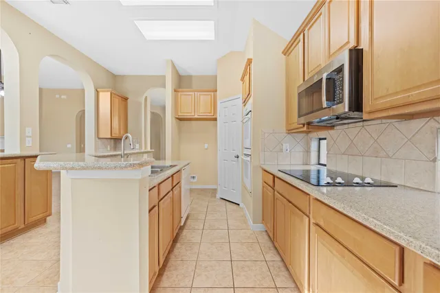 a kitchen with stainless steel appliances granite countertop a sink and a stove