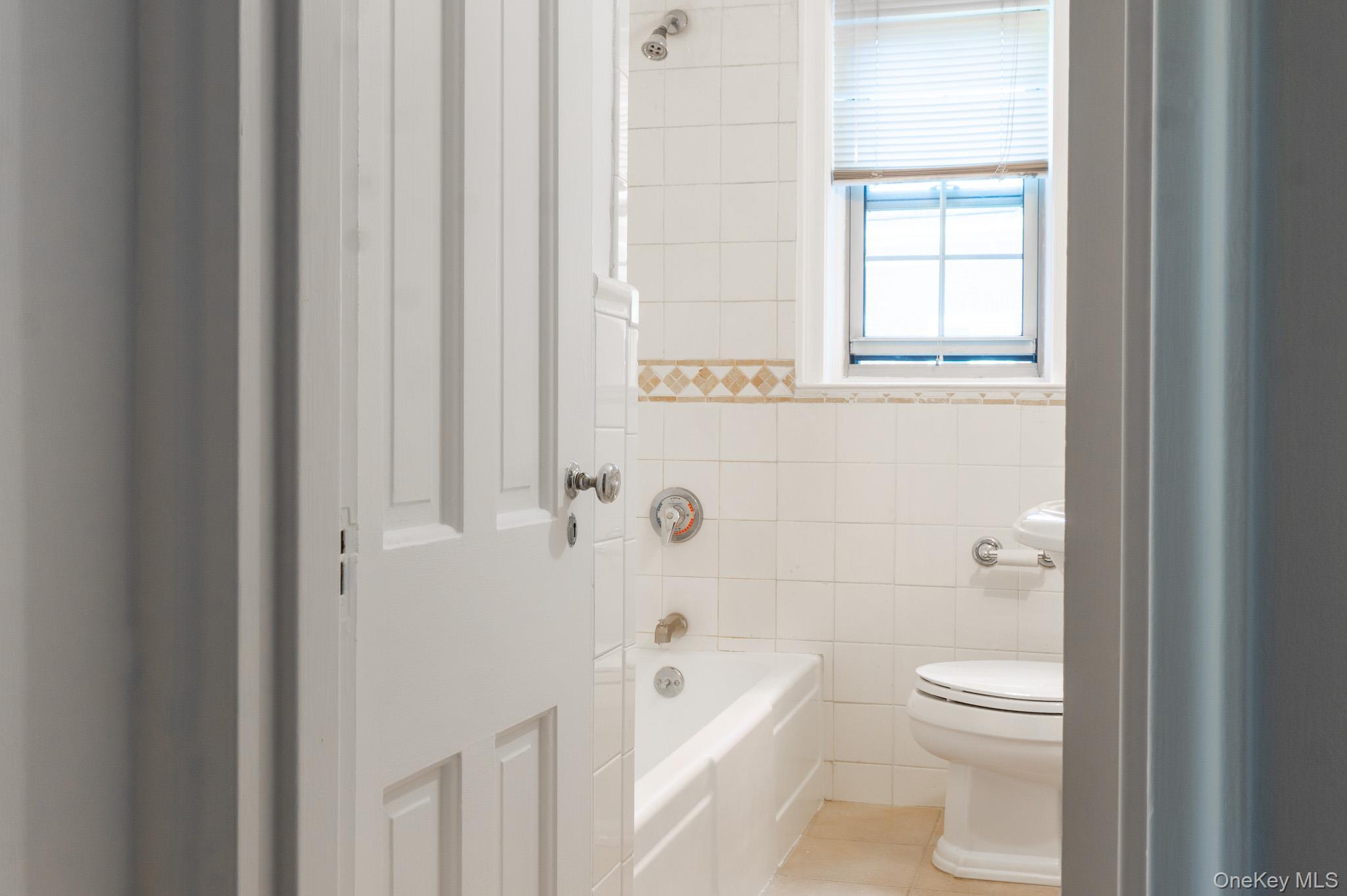 7 Chateaux Circle, Unit 7E Scarsdale, NY 10583 - Photo 18 of 28 Full bathroom featuring tile walls, a bath, and light tile patterned floors