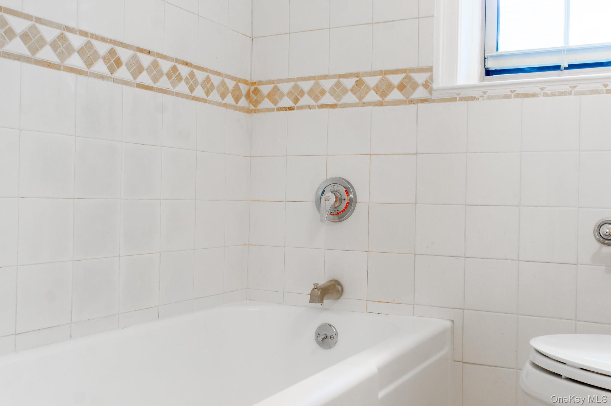 7 Chateaux Circle, Unit 7E Scarsdale, NY 10583 - Photo 19 of 28 Full bathroom with shower combination and tile walls