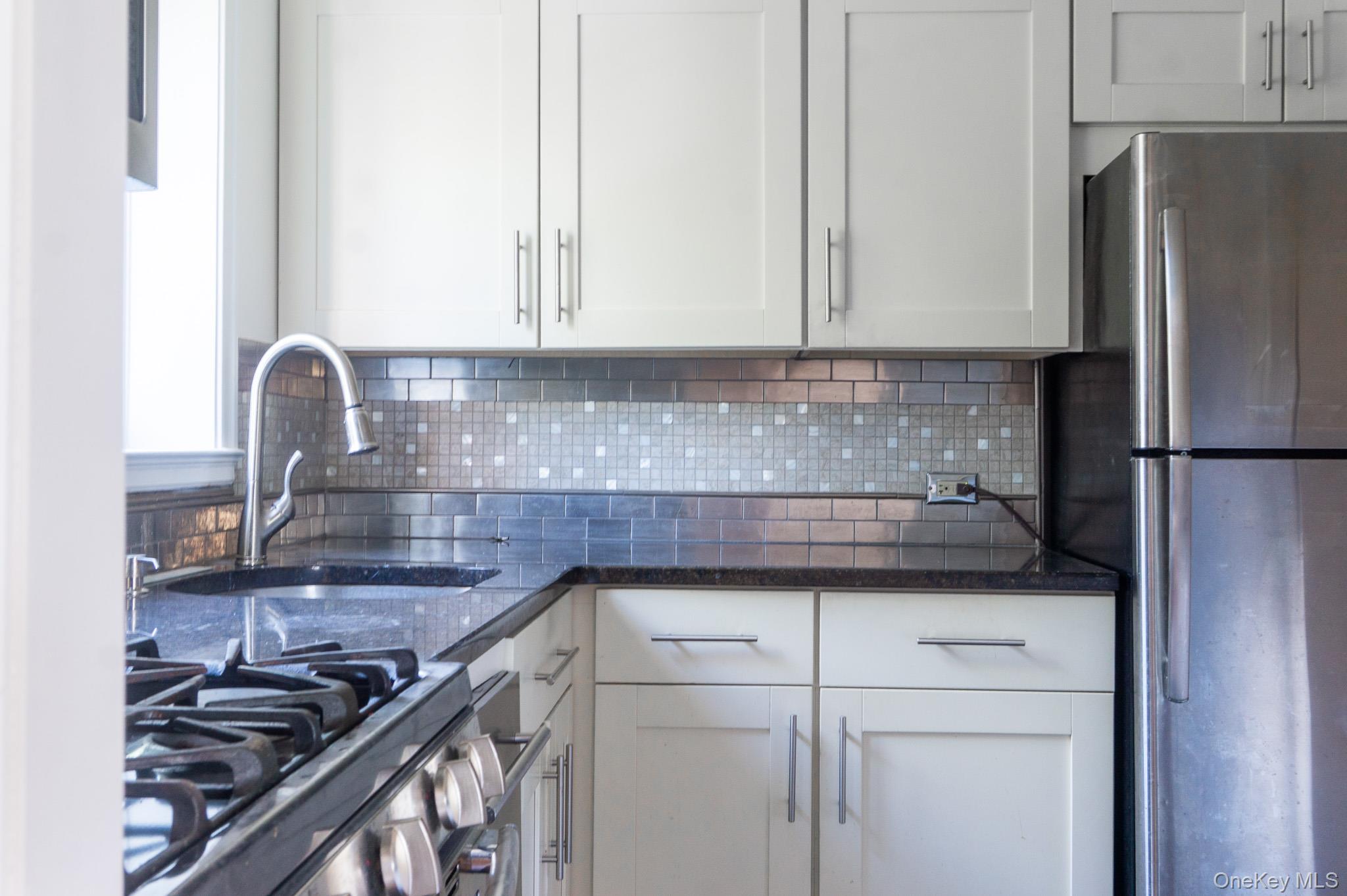 7 Chateaux Circle, Unit 7E Scarsdale, NY 10583 - Photo 9 of 28 Kitchen featuring stainless steel appliances, dark stone countertops, and tasteful backsplash