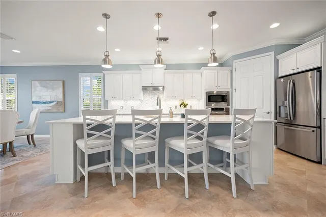 a dining room with kitchen island furniture a large window and stainless steel appliances