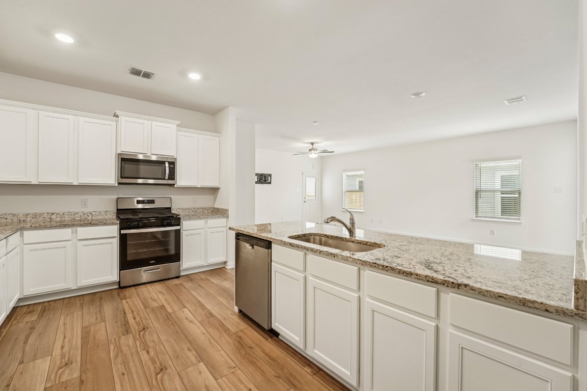 571 Aplite Pass Maxwell, TX 78656 - Photo 19 of 29 a kitchen with granite countertop stainless steel appliances a stove sink and microwave