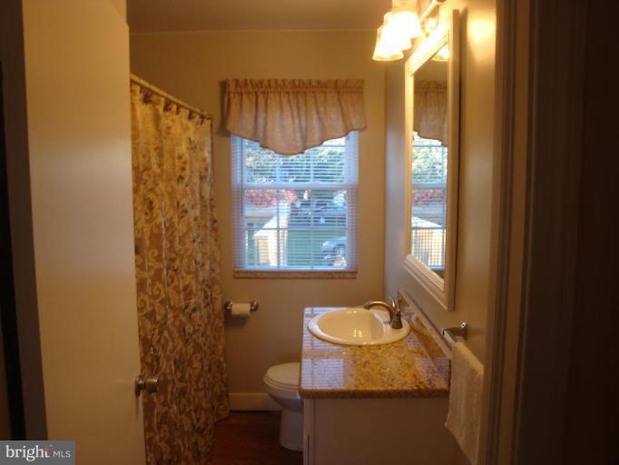 8507 Philadelphia Road Rosedale, MD 21237 - Photo 2 of 14 a bathroom with a granite countertop sink and a mirror