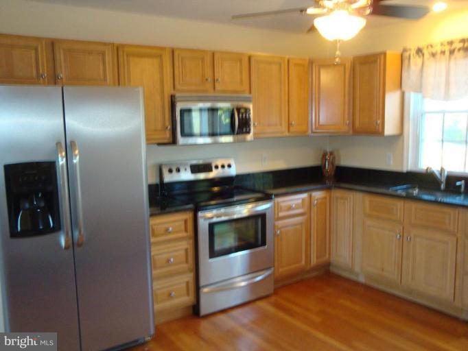 8507 Philadelphia Road Rosedale, MD 21237 - Photo 14 of 14 a kitchen with stainless steel appliances kitchen island granite countertop a stove a sink and a refrigerator