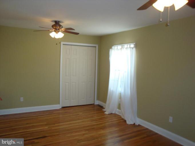 8507 Philadelphia Road Rosedale, MD 21237 - Photo 3 of 14 a view of empty room with wooden floor and fan