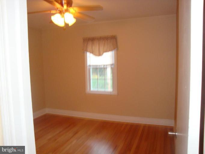 8507 Philadelphia Road Rosedale, MD 21237 - Photo 4 of 14 an empty room with a window and wooden floor