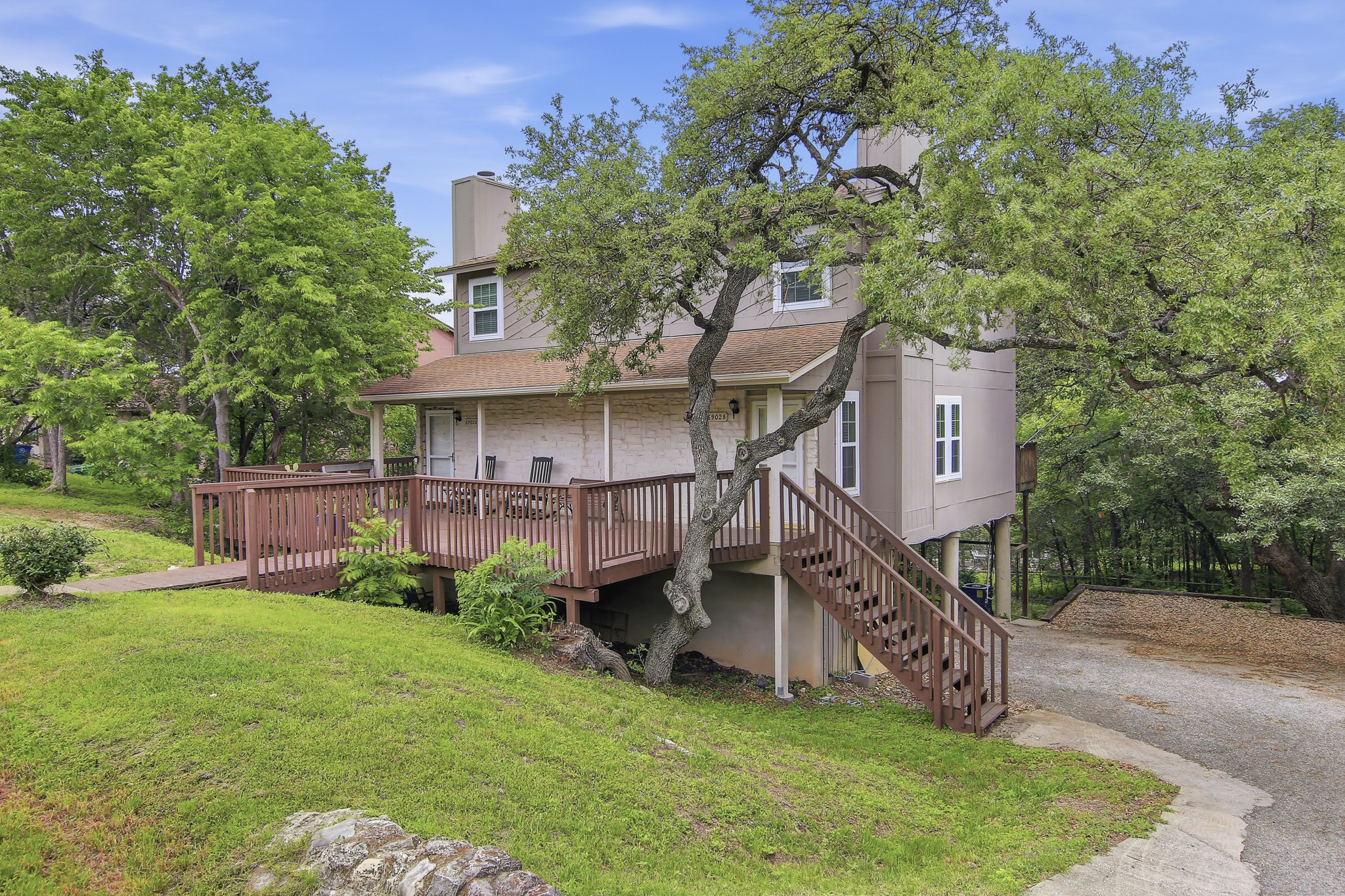 6902 Rifle Bend Austin, TX 78736 - Photo 7 of 33 a view of a house with a big yard potted plants and a large tree