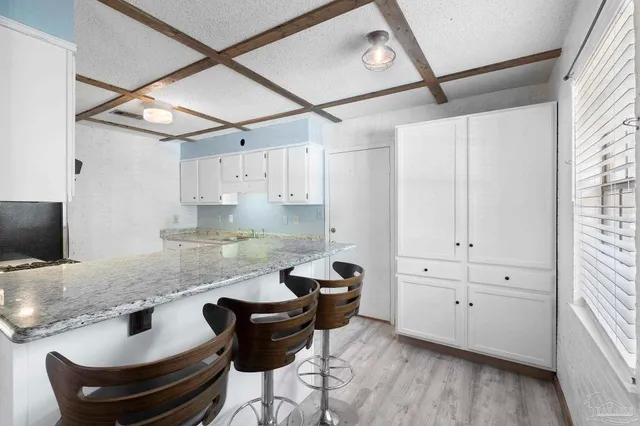 a kitchen with granite countertop a sink cabinets and stainless steel appliances