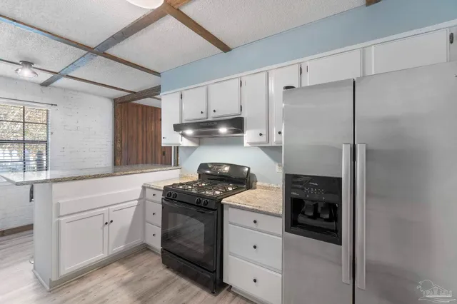 a kitchen with granite countertop a sink stove and refrigerator