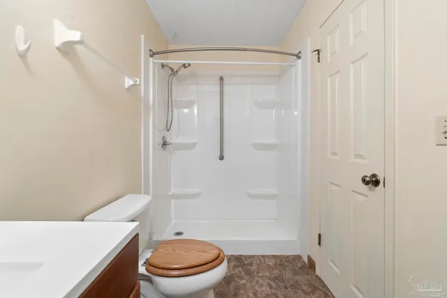 a bathroom with a shower a toilet and sink