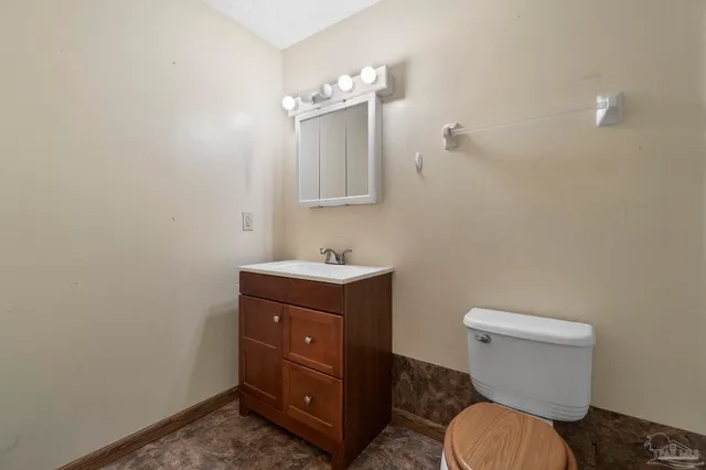 a bathroom with a toilet a sink and mirror