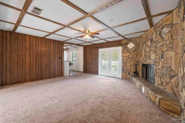 a view of an empty room with a fireplace and a window