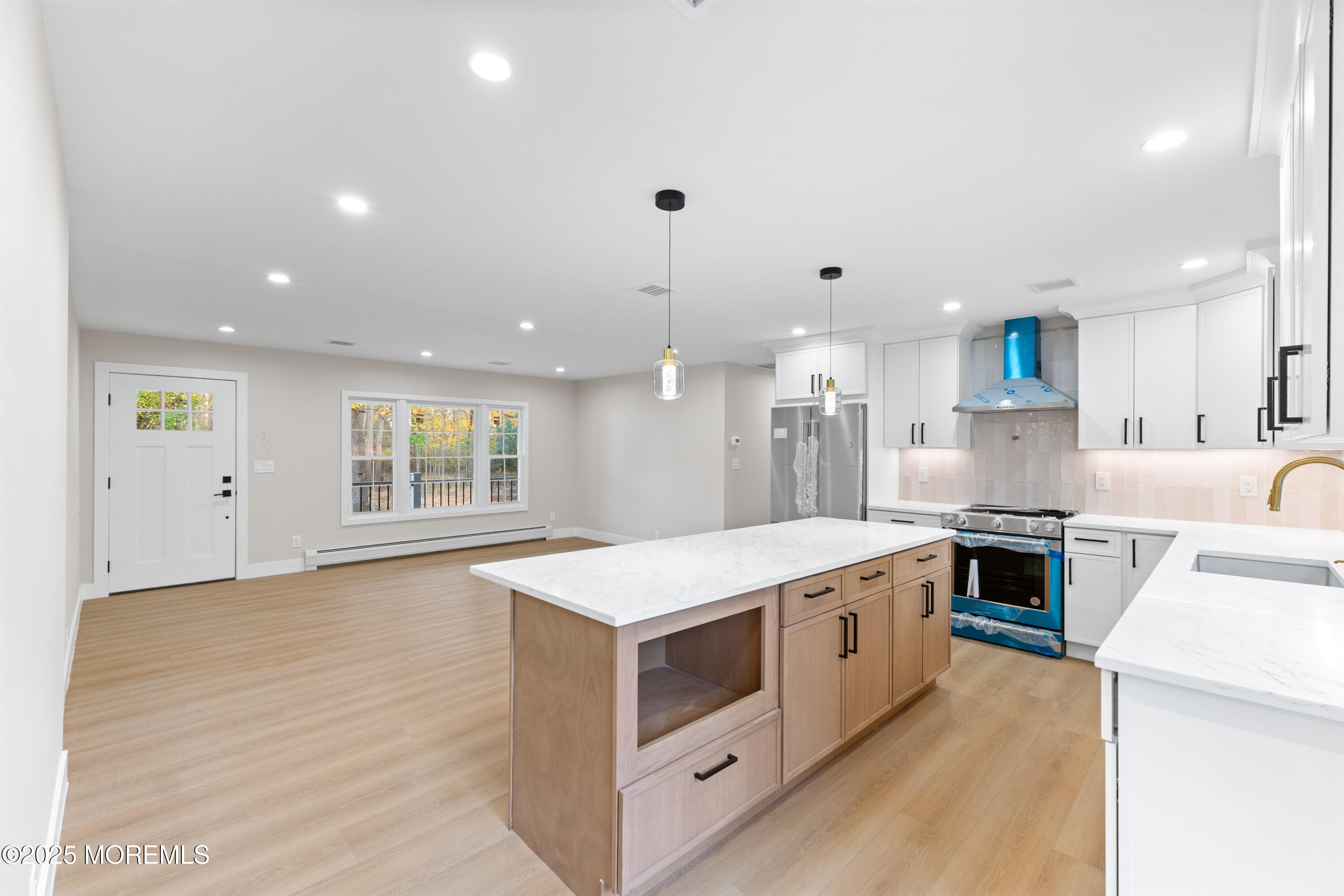 75 Ohio Avenue Middletown, NJ 07758 - Photo 17 of 40 a large white kitchen with stainless steel appliances granite countertop a stove a sink a refrigerator and white cabinets with wooden floor
