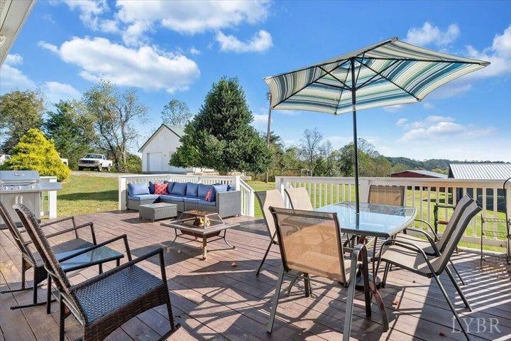 1775 Dickerson Road Goodview, VA 24095 - Photo 13 of 24 a roof deck with a table and chairs under an umbrella