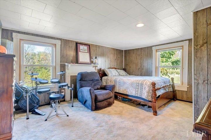 1775 Dickerson Road Goodview, VA 24095 - Photo 9 of 24 a bedroom with a bed chair and a large window