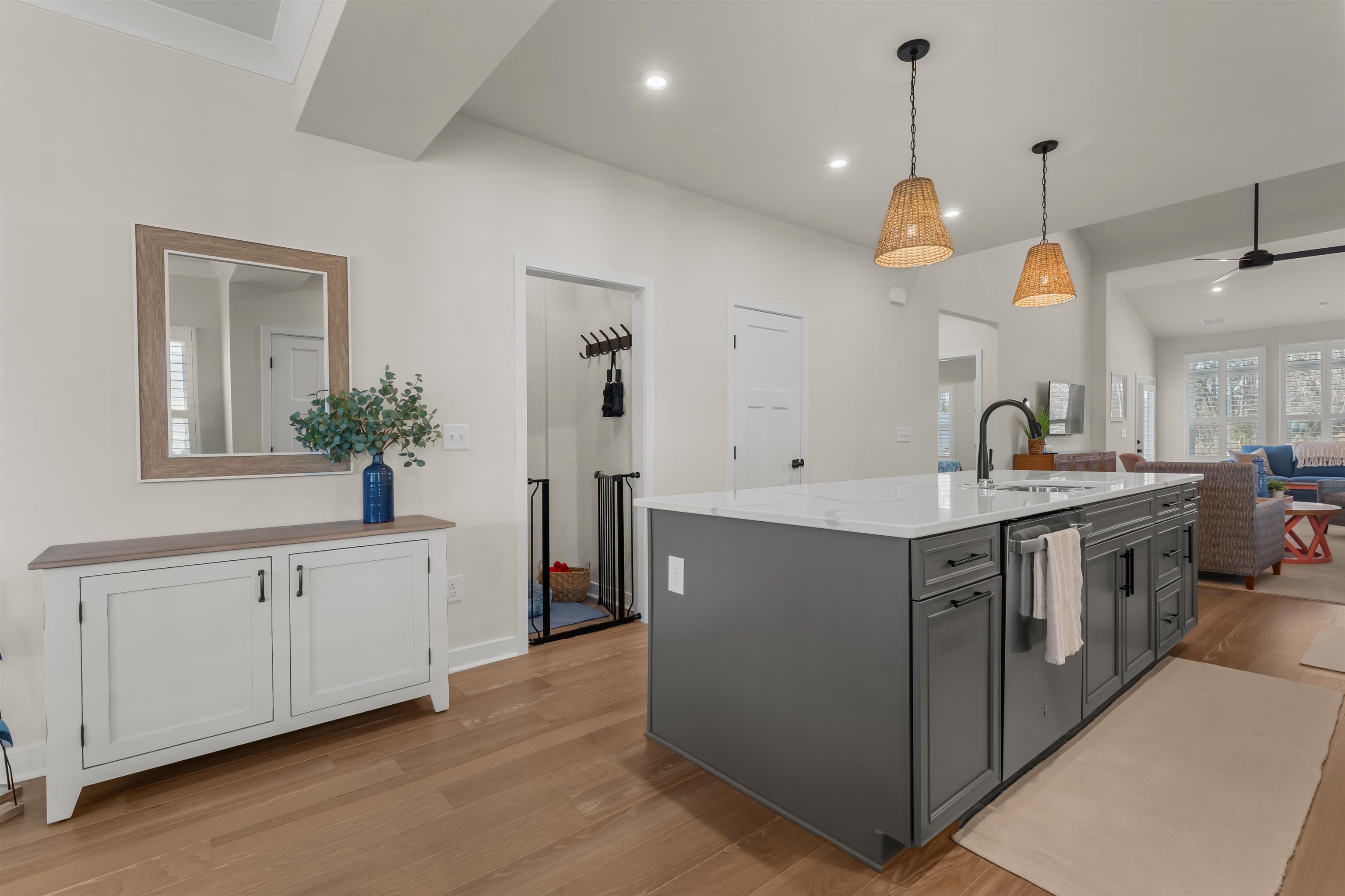 2519 Elowen Lane, Unit 9B Longs, SC 29568 - Photo 38 of 40 Kitchen with light wood finished floors, hanging light fixtures, a center island with sink, gray cabinetry, and open floor plan